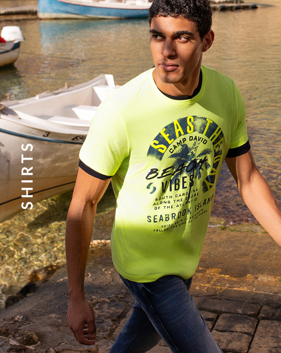 Model trägt Hellgrünes T-Shirt am Wasser